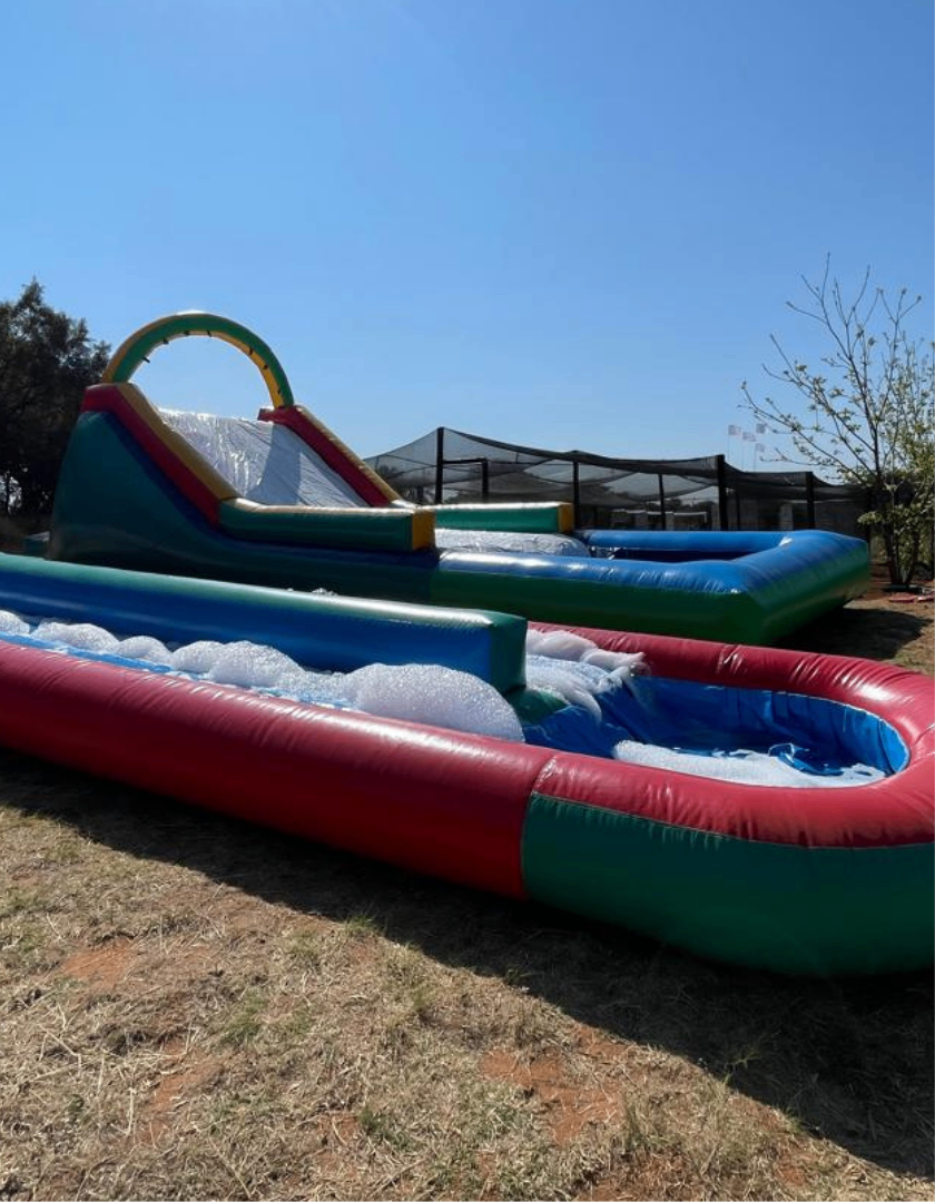 Large outdoor inflatable water slide set up for school activities.